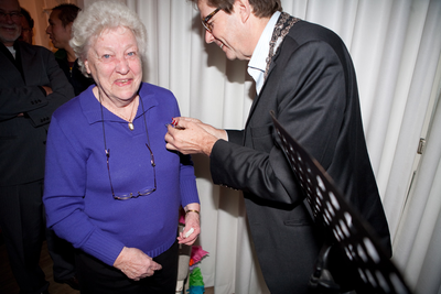 878083 Afbeelding van wethouder Frits Lintmeijer die de oudste vrijwilliger van het museum, Elisabeth ('Bep') Jacobs, ...